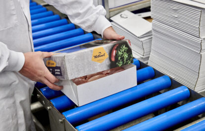 Kip verpakt in bedrukte verpakking op een blauwe rollenband • Solidus